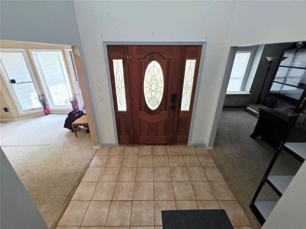 A tiled entryway features a wooden front door with glass inserts and side windows — 2975 E WITHLACOOCHEE TRAIL, DUNNELLON, FL