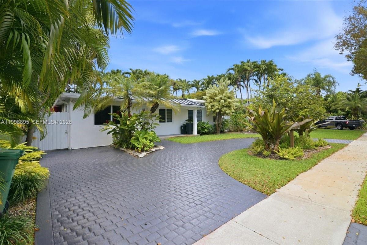 A single-story white house features a paved driveway, lush landscaping, and palm trees — 6133 SW 44th Ter, Miami FL 33155, MIAMI, FL