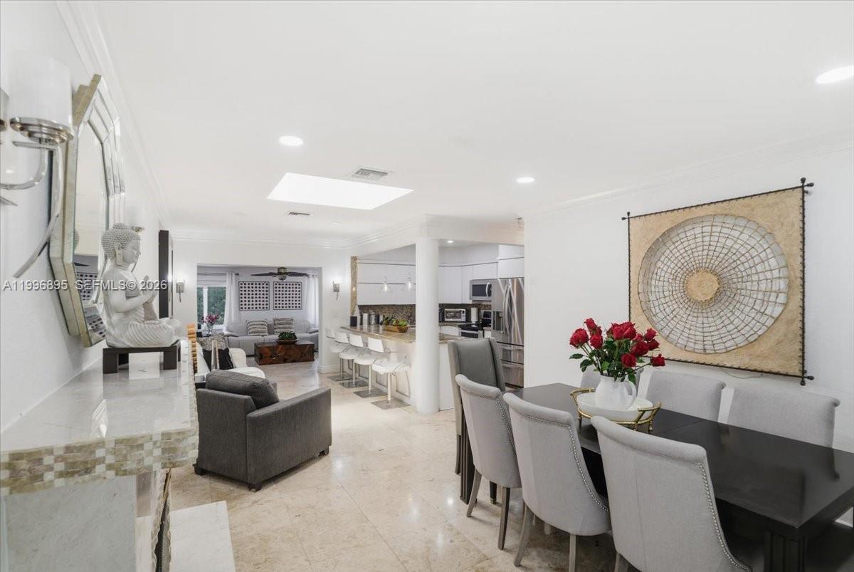 This open-concept dining and living area features marble floors, a kitchen island, and skylights — 6133 SW 44th Ter, Miami FL 33155, MIAMI, FL