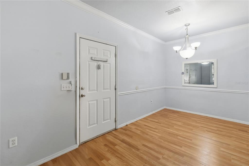A dining room with light gray walls, hardwood floors, a white door, and a chandelier — 3379 S KIRKMAN ROAD UNIT 1027, ORLANDO, FL