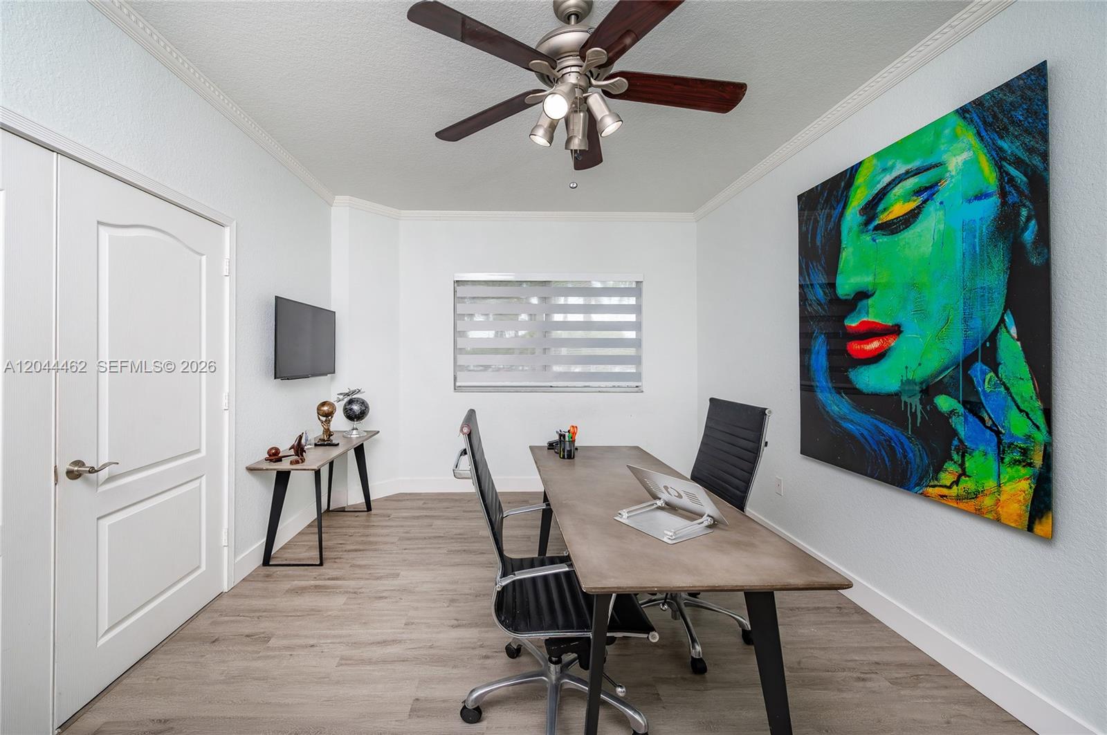 This home office features a desk, two chairs, a ceiling fan, and large wall art — 10700 NW 66th St # 204, Doral FL 33178, DORAL, FL