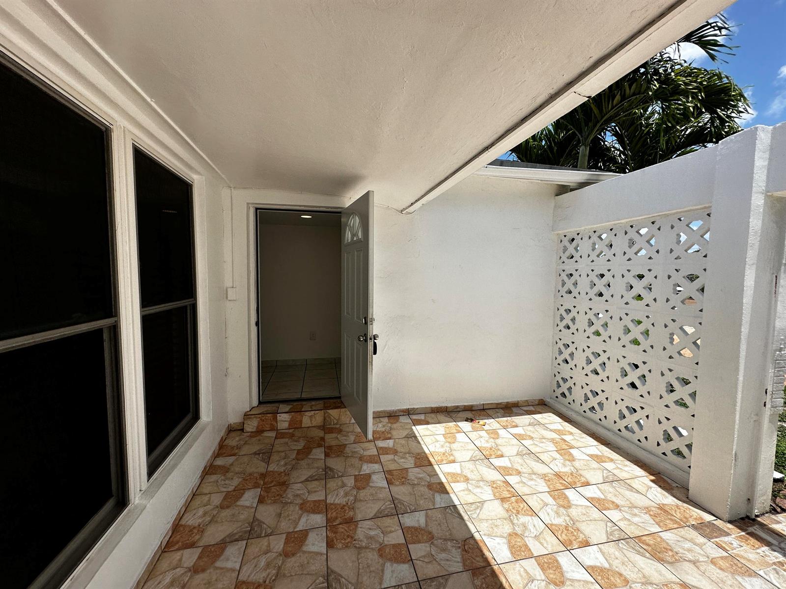 A covered patio with patterned tile flooring and a decorative white breeze block wall — 7725 Grandview Boulevard # 7725, Miramar FL 33023, MIRAMAR, FL