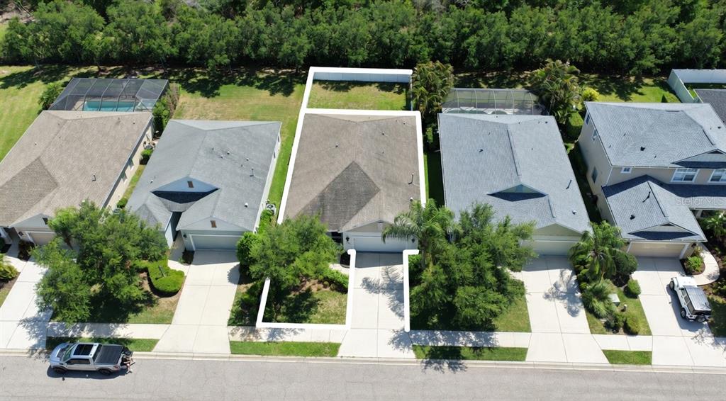 An aerial view shows a single-family house with a driveway and backyard in a neighborhood — 4650 WOODBROOK DRIVE, SARASOTA, FL