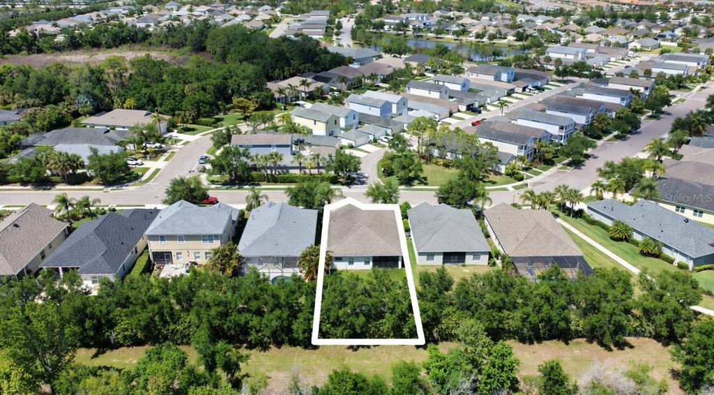 An aerial view shows a single-family home with a highlighted backyard in a suburban neighborhood — 4650 WOODBROOK DRIVE, SARASOTA, FL