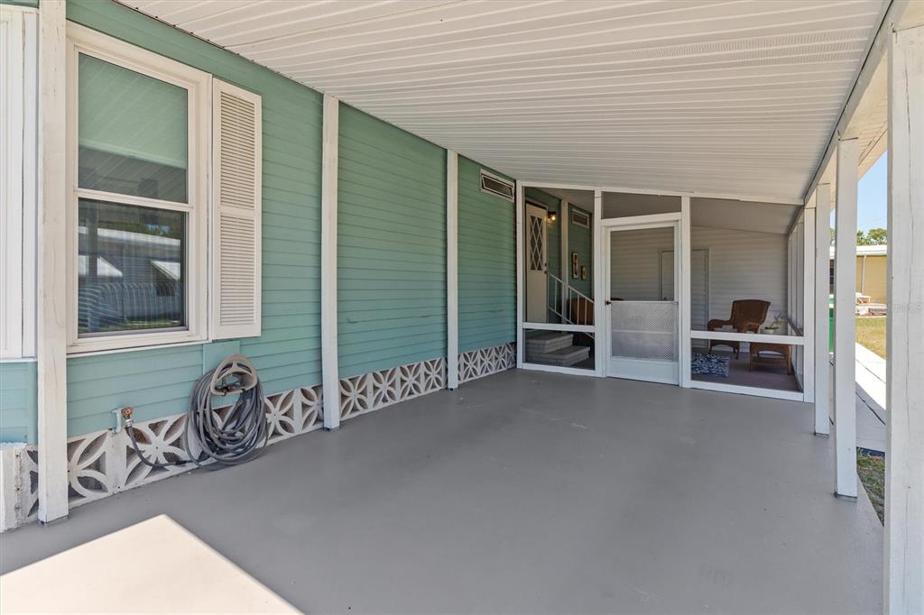 A covered patio features light blue siding, a gray concrete floor, and a screened enclosure — 3308 GOLDFINCH, ENGLEWOOD, FL