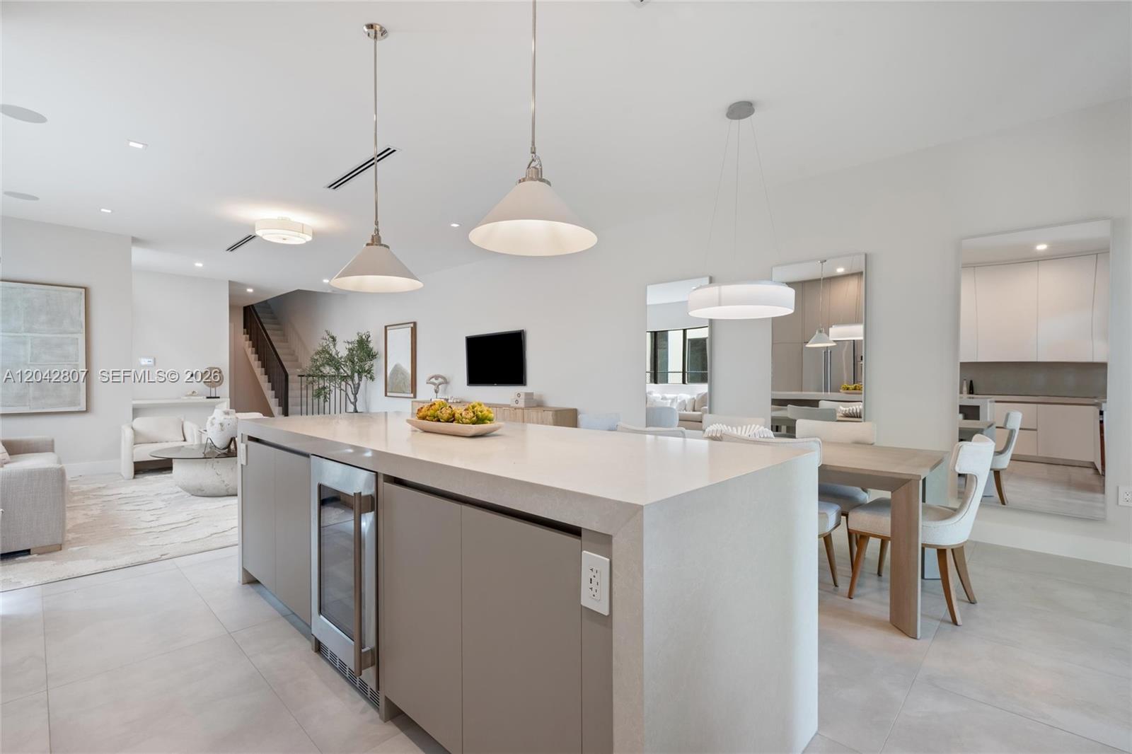 A modern kitchen features a large island with a wine cooler and pendant lighting — 2747 SW 23rd Ter, Miami FL 33145, MIAMI, FL