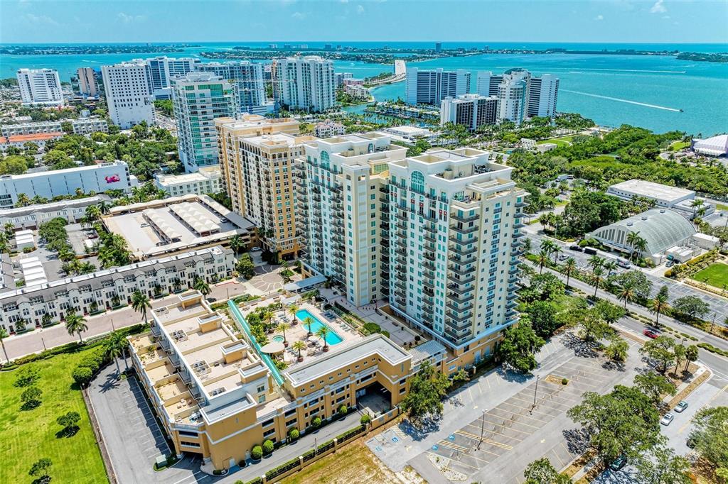 An aerial view shows a large residential complex with a swimming pool and parking lots — 800 N TAMIAMI TRAIL UNIT 212, SARASOTA, FL