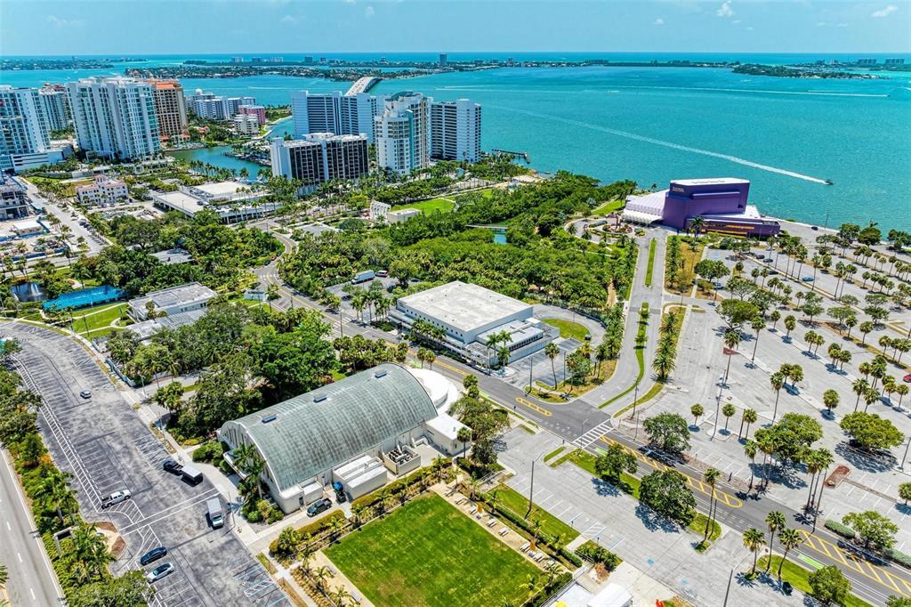 An aerial view shows a coastal area with buildings, parking lots, and green spaces — 800 N TAMIAMI TRAIL UNIT 212, SARASOTA, FL