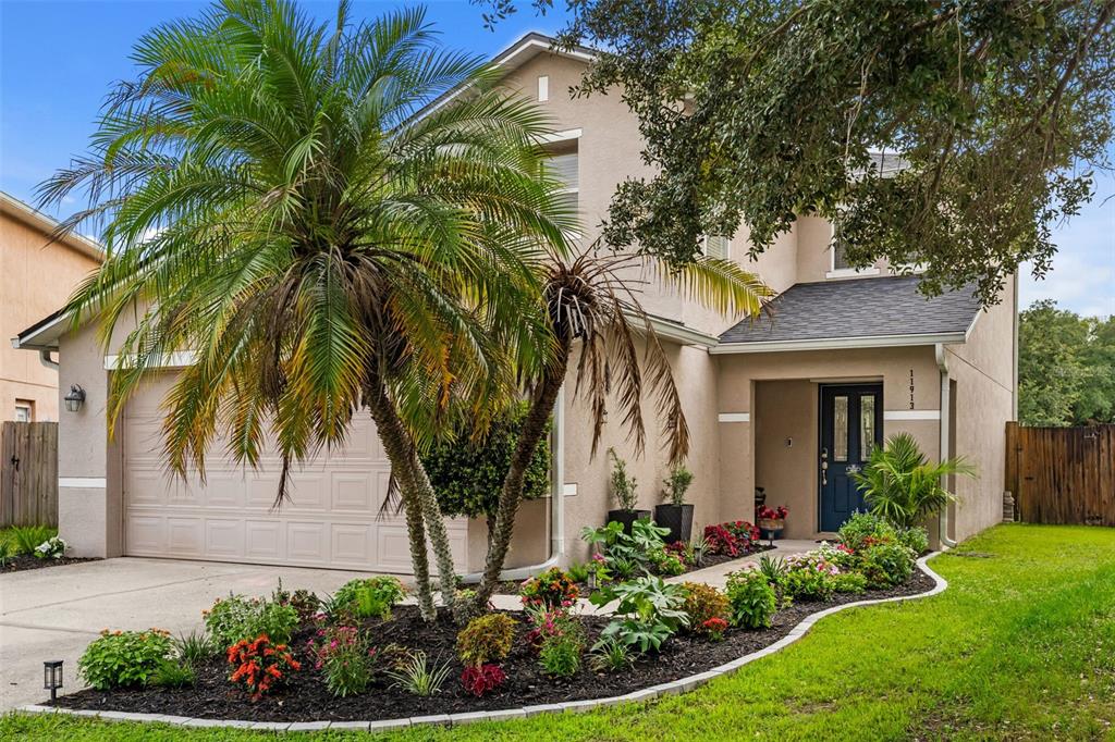 A two-story house exterior features a patio with outdoor furniture and a swimming pool — 11913 MANGO GROVES BOULEVARD, SEFFNER, FL