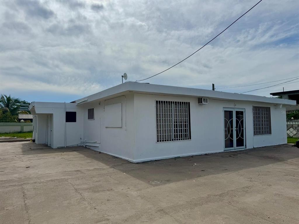 A white, single-story building with a flat roof and security bars on the windows — 690 St. BO. SABANA, VEGA ALTA, PR