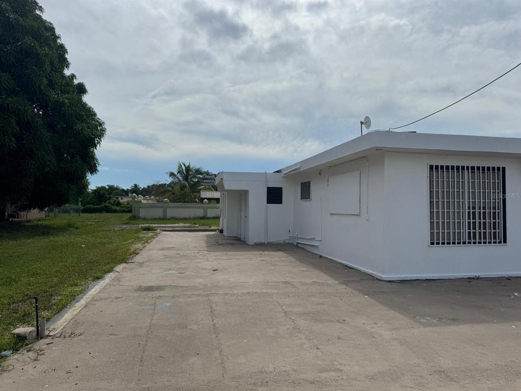 A white concrete building with a flat roof and a large paved driveway area — 690 St. BO. SABANA, VEGA ALTA, PR