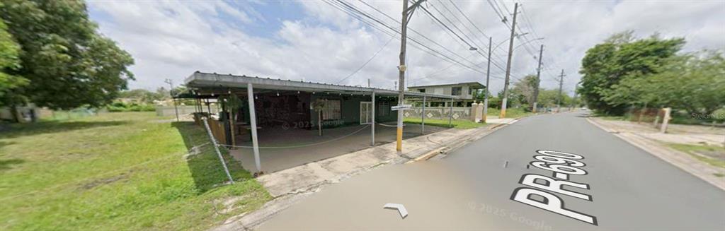 A single-story building with a large covered patio sits along a paved road — 690 St. BO. SABANA, VEGA ALTA, PR