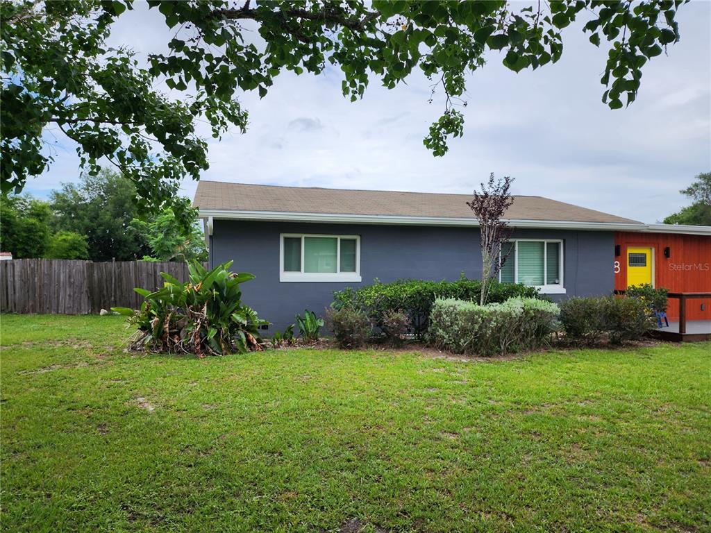 A gray single-story house features a bright yellow front door and a large front lawn — 8 POINSETTIA DRIVE, DEBARY, FL