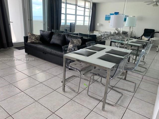 A living and dining area features a black sofa, glass table, and tiled flooring — 100 LINCOLN RD # 1236, Miami Beach FL 33139, MIAMI BEACH, FL