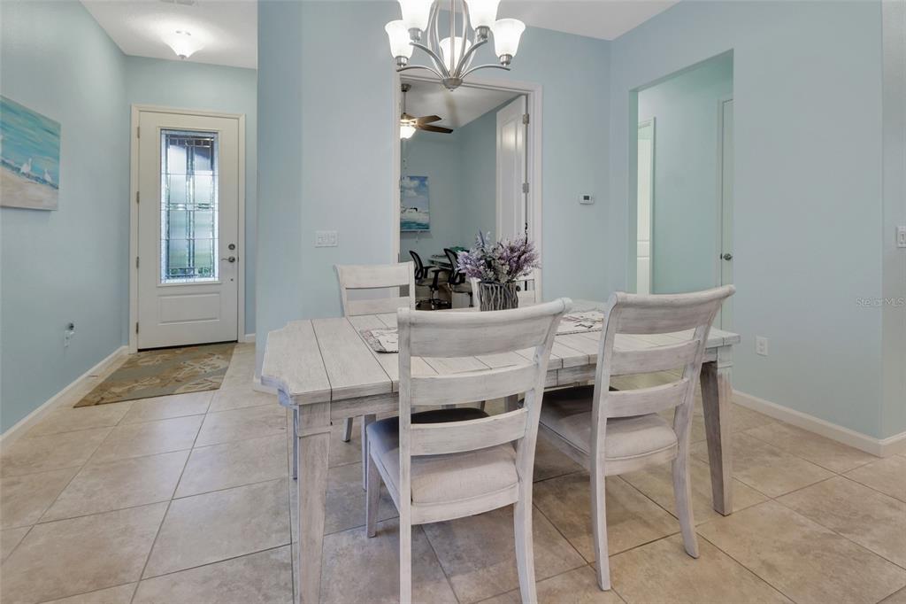 A dining area features a white wooden table and chairs set against light blue walls — 412 TISBURY COURT, DELAND, FL