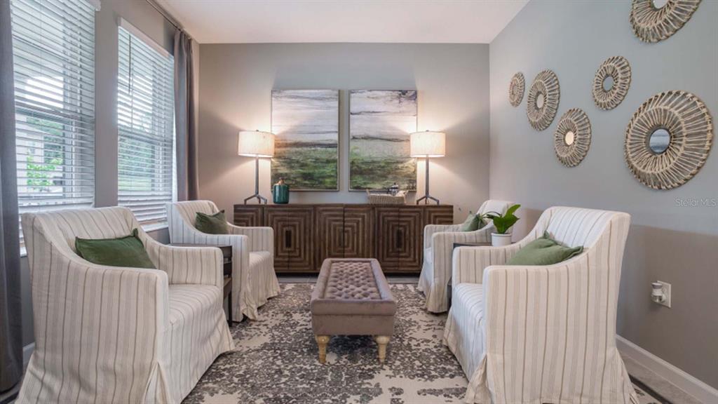 A sitting room features four striped armchairs, a central ottoman, and wall-mounted decorative woven mirrors — 5620 FIONA LANE, ST CLOUD, FL
