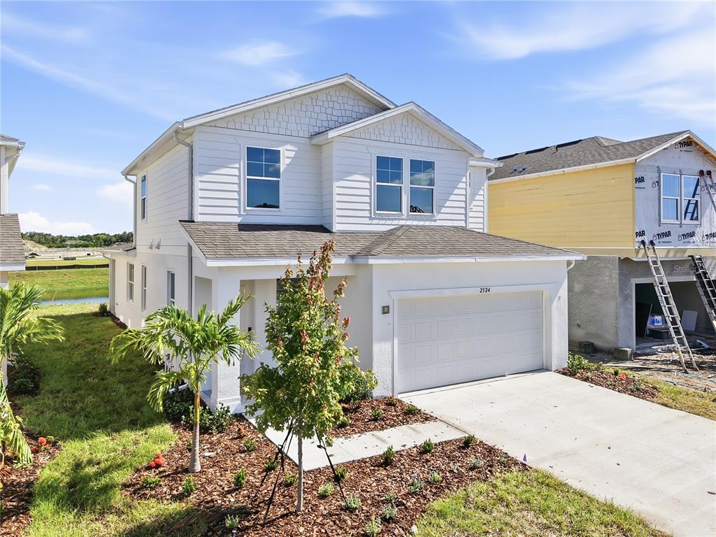 A two-story white house with a two-car garage and a small front yard — 2524 29TH LANE E, PALMETTO, FL