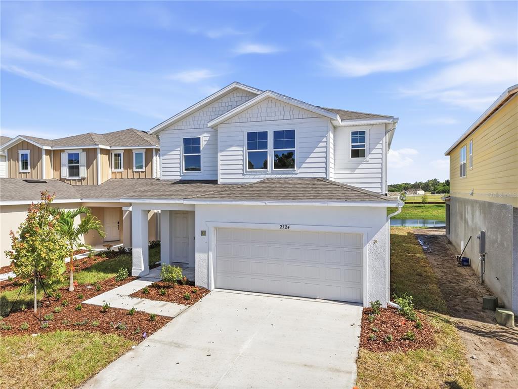 A two-story white house with a two-car garage and a concrete driveway — 2524 29TH LANE E, PALMETTO, FL