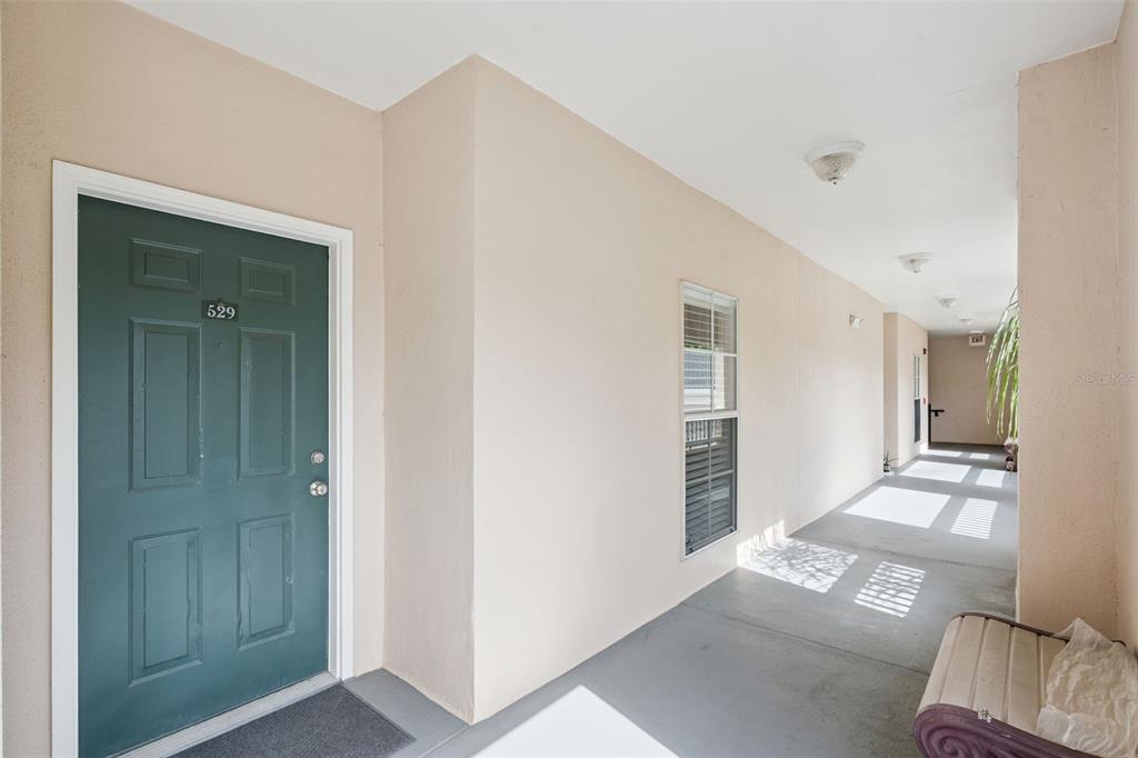 A kitchen features light wood cabinets, a white countertop, stainless steel appliances, and teal backsplash — 529 WATER STREET UNIT 529, CELEBRATION, FL