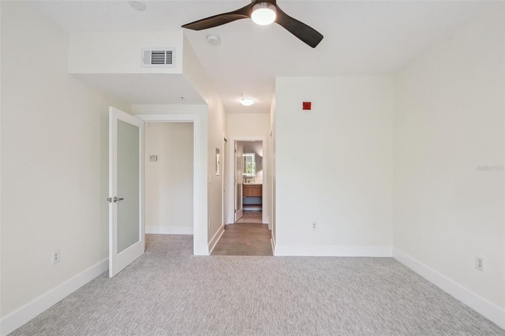 A kitchen features light wood cabinets, stainless steel appliances, a teal backsplash, and white countertops — 529 WATER STREET UNIT 529, CELEBRATION, FL