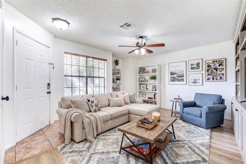 A living room features a beige sectional sofa, a blue armchair, and a wooden coffee table — 2901 WAREHAM COURT, CASSELBERRY, FL