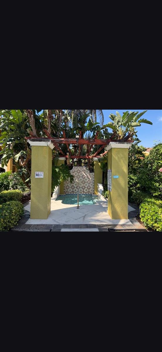 A small outdoor hot tub is framed by two yellow pillars and a wooden pergola — 2090 W Preserve Way # 206, Miramar FL 33025, MIRAMAR, FL