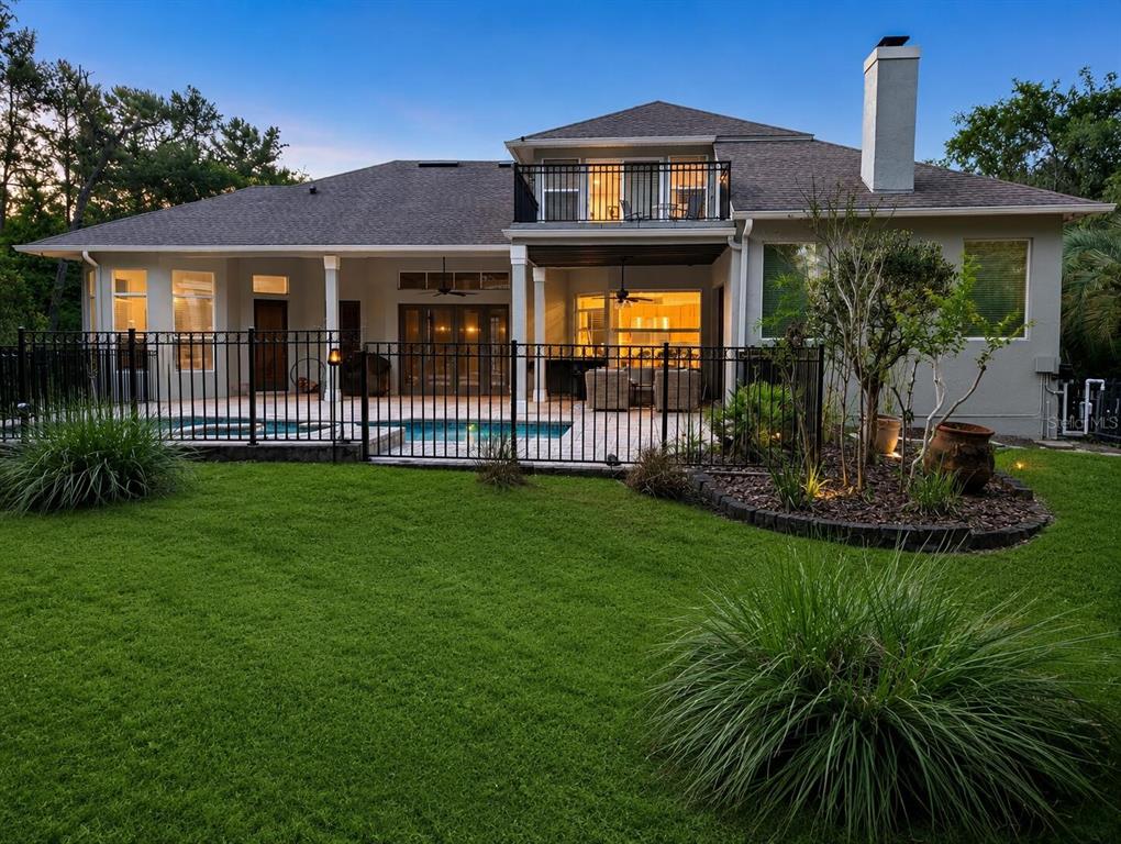 The backyard features a swimming pool, a covered patio, and a second-story balcony — 301 SEMINOLE WOODS BOULEVARD, GENEVA, FL