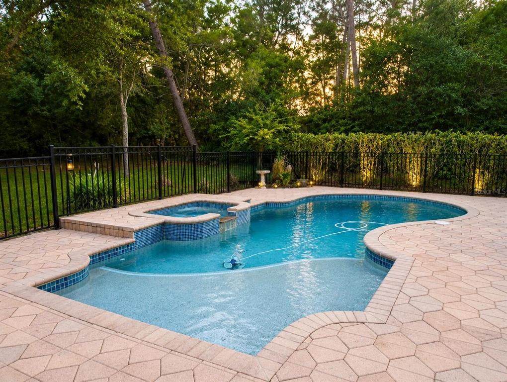 A backyard swimming pool with an attached spa and stone paver deck enclosed by fencing — 301 SEMINOLE WOODS BOULEVARD, GENEVA, FL