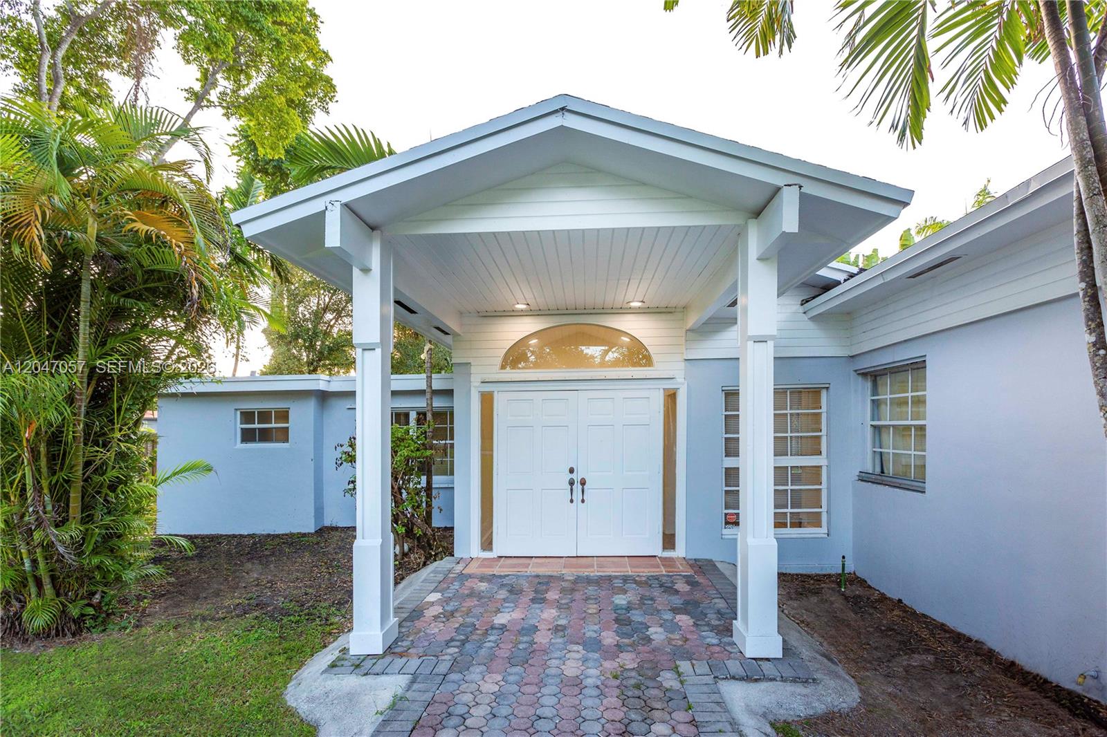 A light blue house features a covered entryway with white columns and double front doors — 5451 SW 80th St, Miami FL 33143, MIAMI, FL