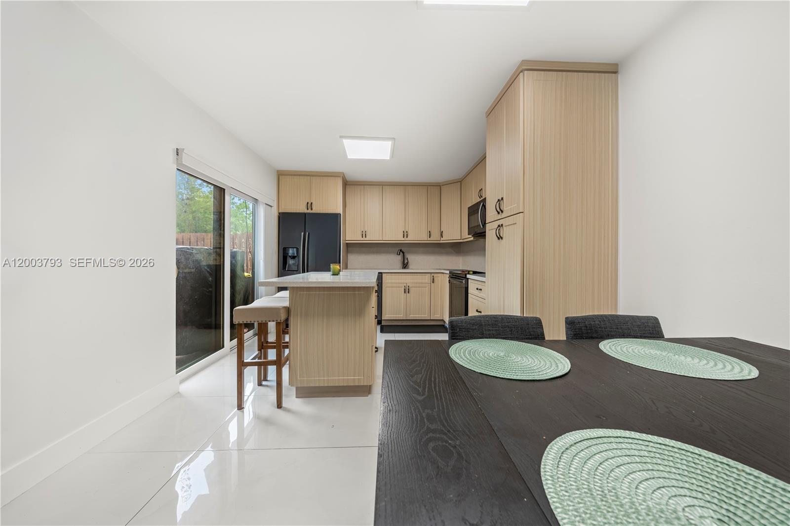 A kitchen with light wood cabinets, a center island, and a dining area — 4089 Forest Hill Dr, Cooper City FL 33026, COOPER CITY, FL