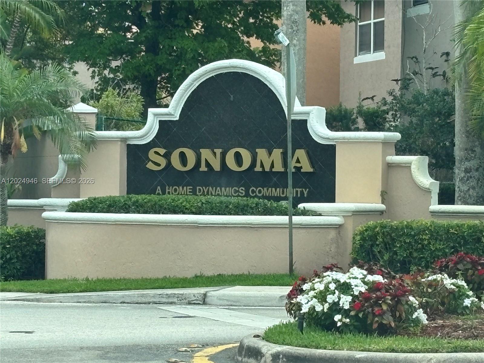 A beige stucco monument sign for the Sonoma community stands near a landscaped road entrance — 9283 NW 54th St, Sunrise FL 33351, SUNRISE, FL