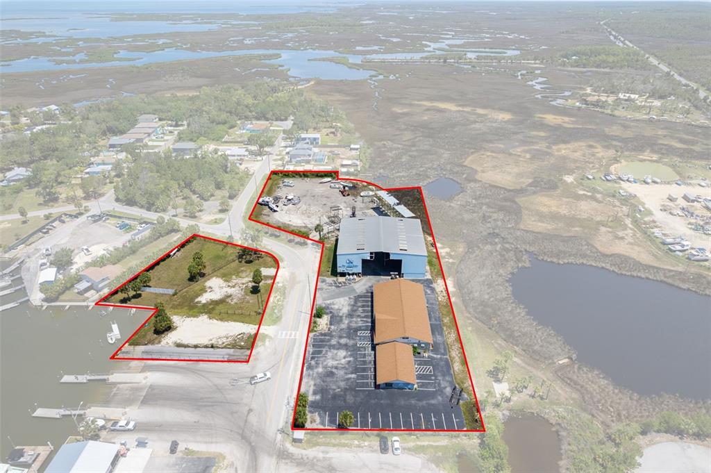 An aerial view shows two adjacent commercial properties outlined in red near a waterway — 4984 CALIENTA STREET, HERNANDO BEACH, FL