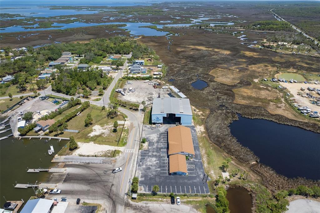 An aerial view shows a boat storage facility, parking lot, and boat ramp near wetlands — 4984 CALIENTA STREET, HERNANDO BEACH, FL