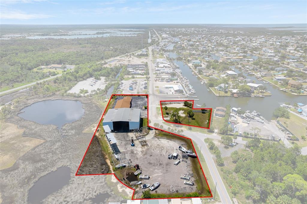 An aerial view shows a commercial property with a warehouse and boat storage yard — 4984 CALIENTA STREET, HERNANDO BEACH, FL