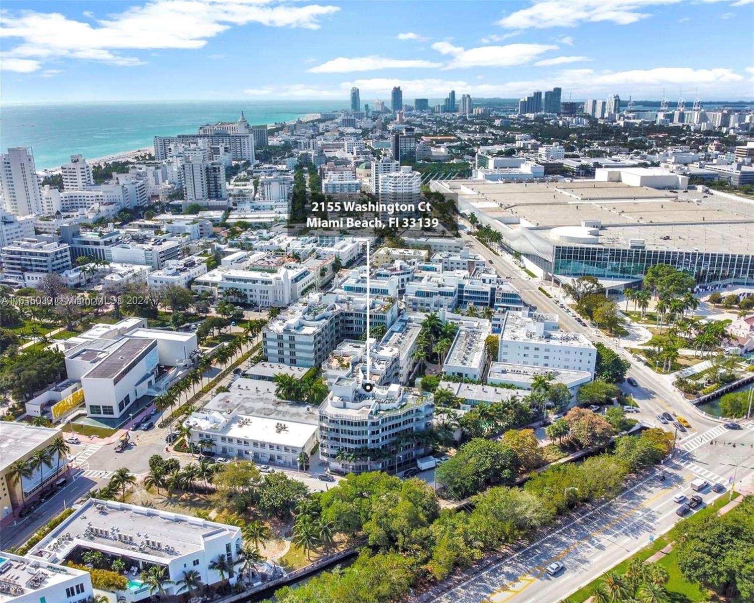 An aerial view shows a multi-story residential building complex surrounded by city streets and trees — 2155 Washington Ct # 206, Miami Beach FL 33139, MIAMI BEACH, FL