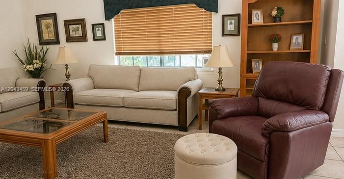 A living room features a beige sofa, a dark leather recliner, and a wooden coffee table — 9812 SW 77th Pl, Miami FL 33156, MIAMI, FL
