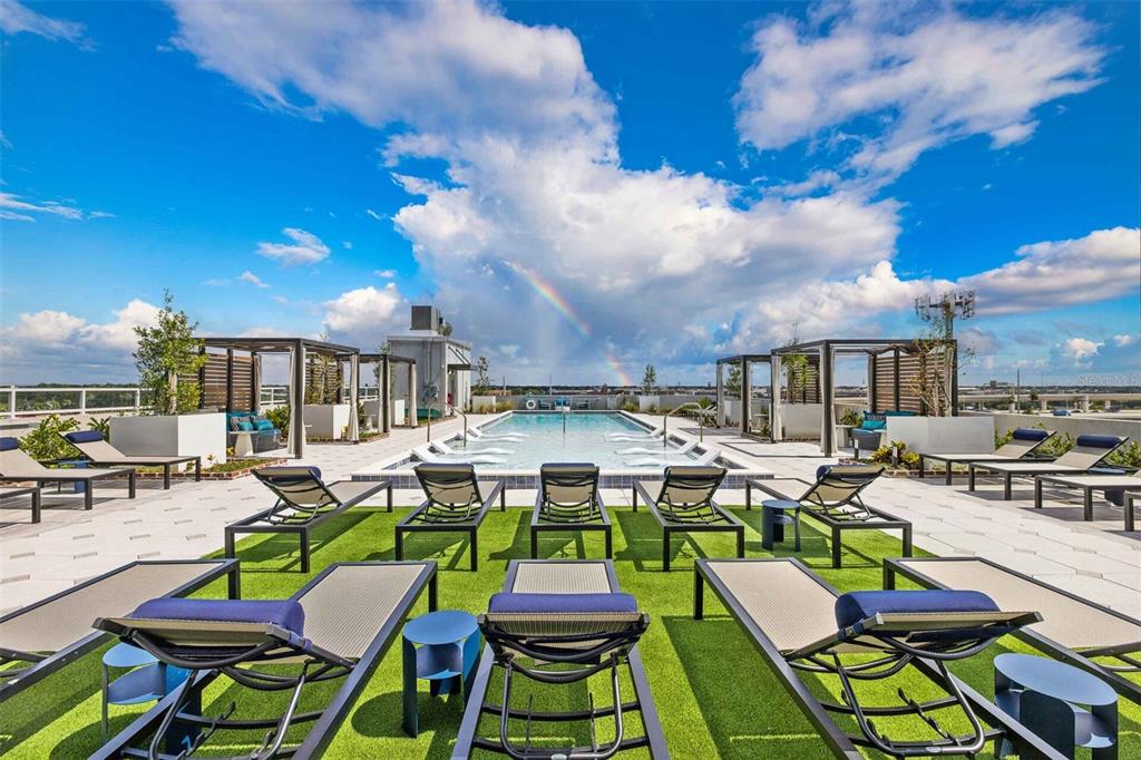 A rooftop swimming pool area features lounge chairs on artificial turf under a cloudy sky — 601 N 12TH STREET N UNIT A2, TAMPA, FL