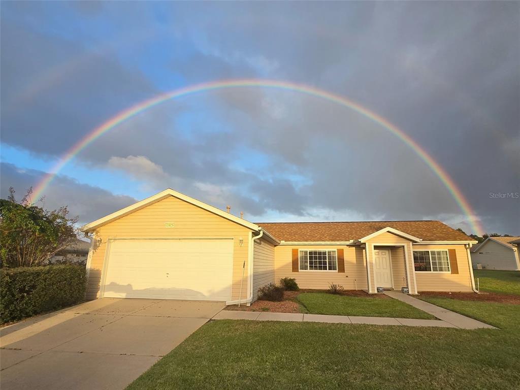 A single-story house with a garage and a double rainbow in the sky above — 13828 SE 85TH CIRCLE, SUMMERFIELD, FL