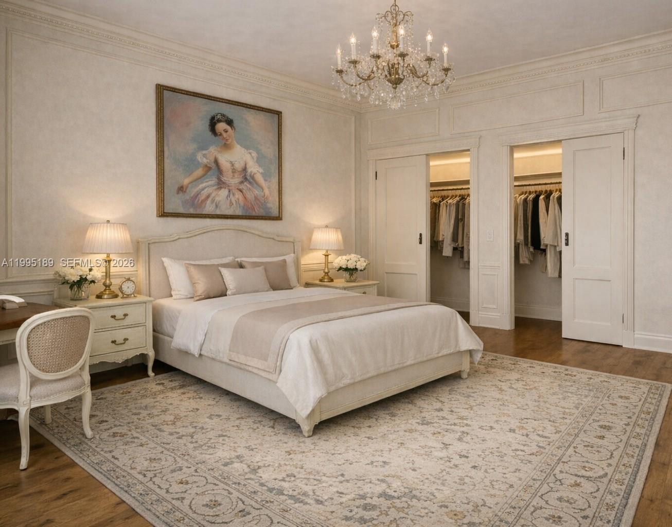 A bedroom features a bed, chandelier, painting, and two open closets with hanging clothes — 10185 Collins Ave # 308, Bal Harbour FL 33154, BAL HARBOUR, FL