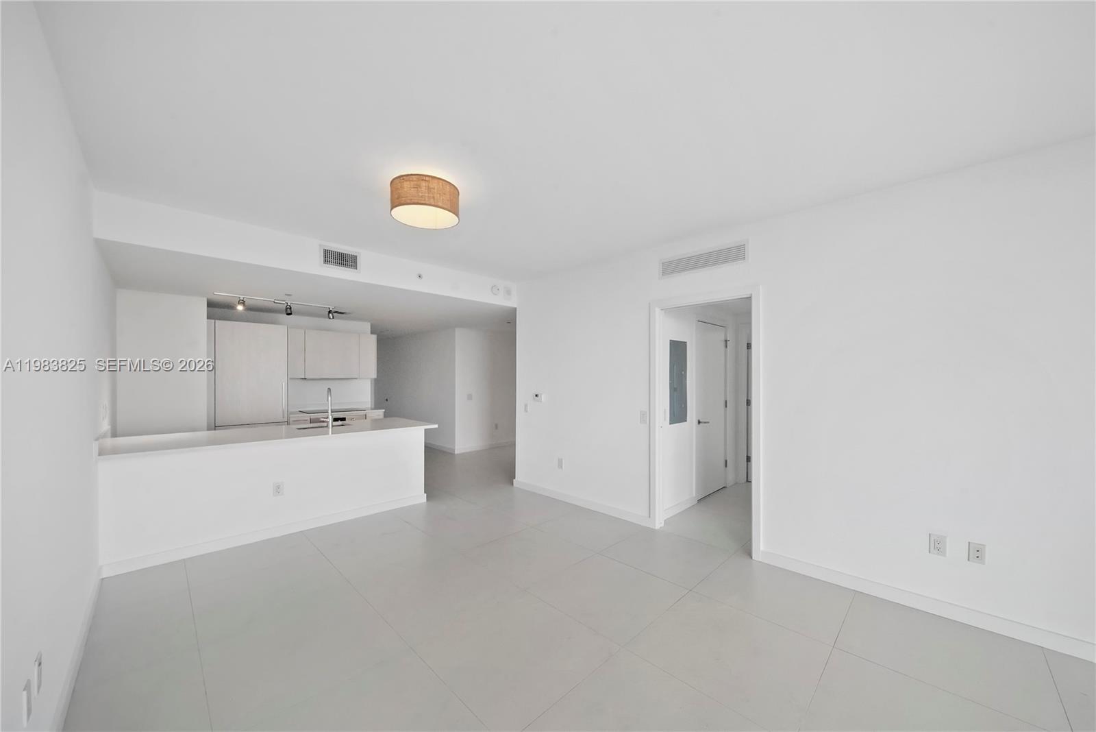 An open-concept living area features white walls, light tile flooring, and a modern kitchen — 501 NE 31st St # 3110, Miami FL 33137, MIAMI, FL