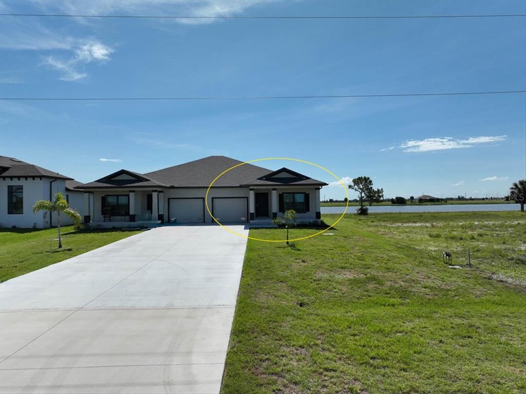 A duplex home with a concrete driveway and a view of a lake — 44 YELLOWHAMMER DRIVE, PLACIDA, FL