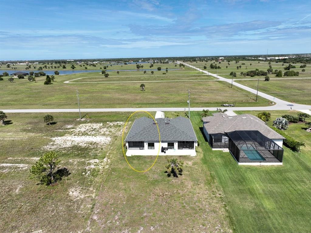 An aerial view shows a single-story house with a gray roof and a screened-in porch — 44 YELLOWHAMMER DRIVE, PLACIDA, FL