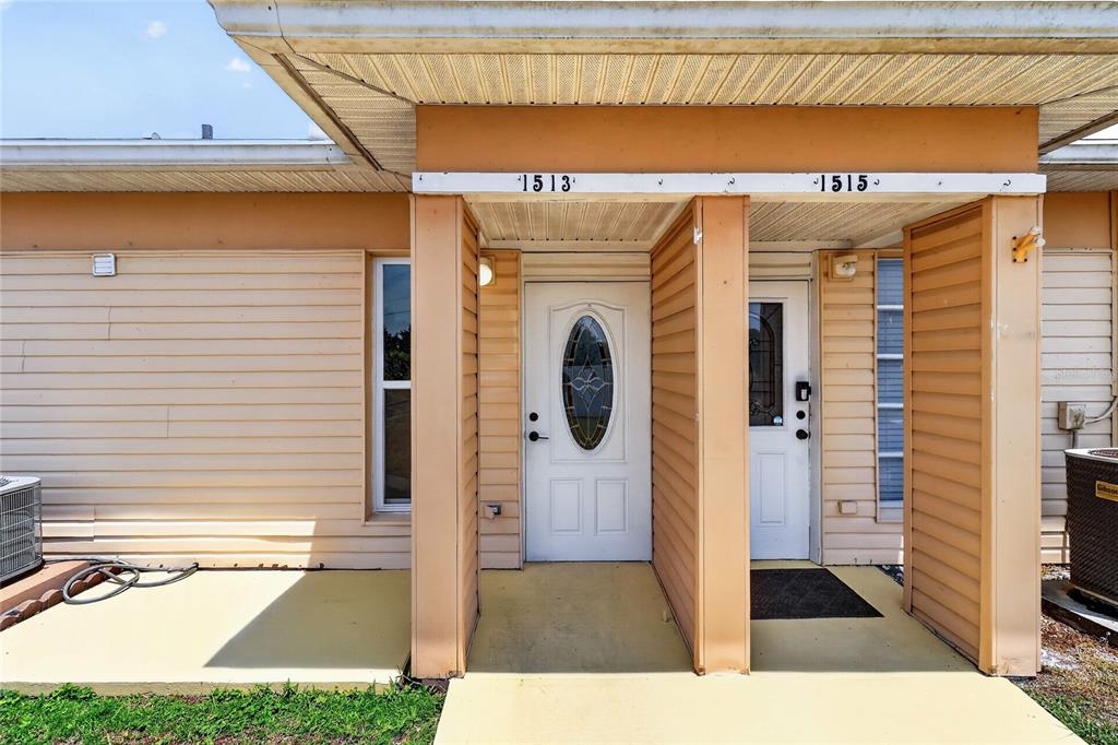 The exterior of a duplex features two adjacent front doors under a covered porch — 1513 CLUB CIRCLE, LAKESHORE, FL