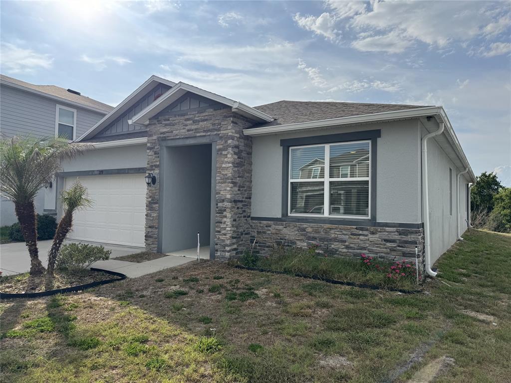 A single-story house with a stone facade, a two-car garage, and a front lawn — 279 SUNFISH DRIVE DRIVE, WINTER HAVEN, FL