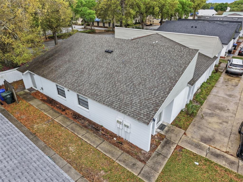 An aerial view shows the exterior of a white building with a shingled roof — 1912-1918 CRYSTAL GROVE DRIVE, LAKELAND, FL