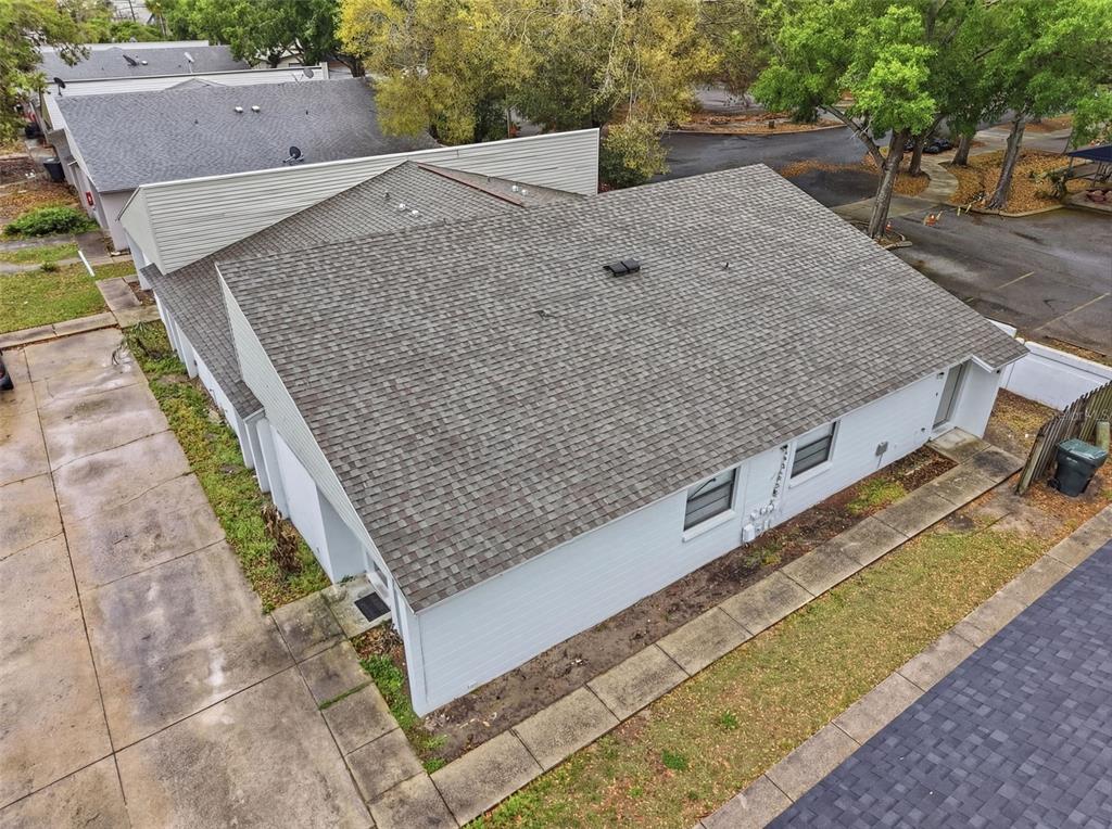 An aerial view shows the exterior of a light-colored building with a shingled roof — 1912-1918 CRYSTAL GROVE DRIVE, LAKELAND, FL