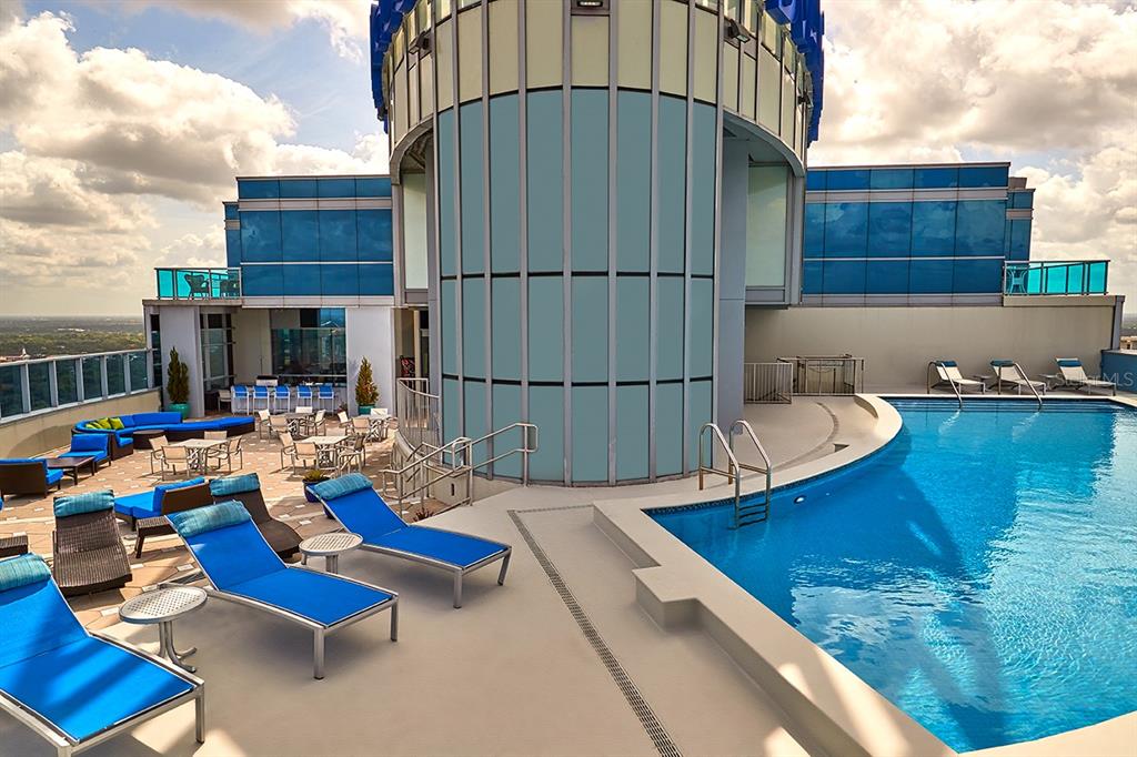 A rooftop terrace features a swimming pool, lounge chairs, and outdoor seating with city views — 111-4 WASHINGTON STREET, ORLANDO, FL