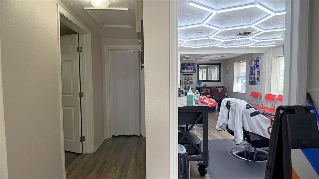 A view from a hallway into a barbershop featuring hexagon-patterned ceiling lights and chairs — 325 NE 25 AVENUE, OCALA, FL
