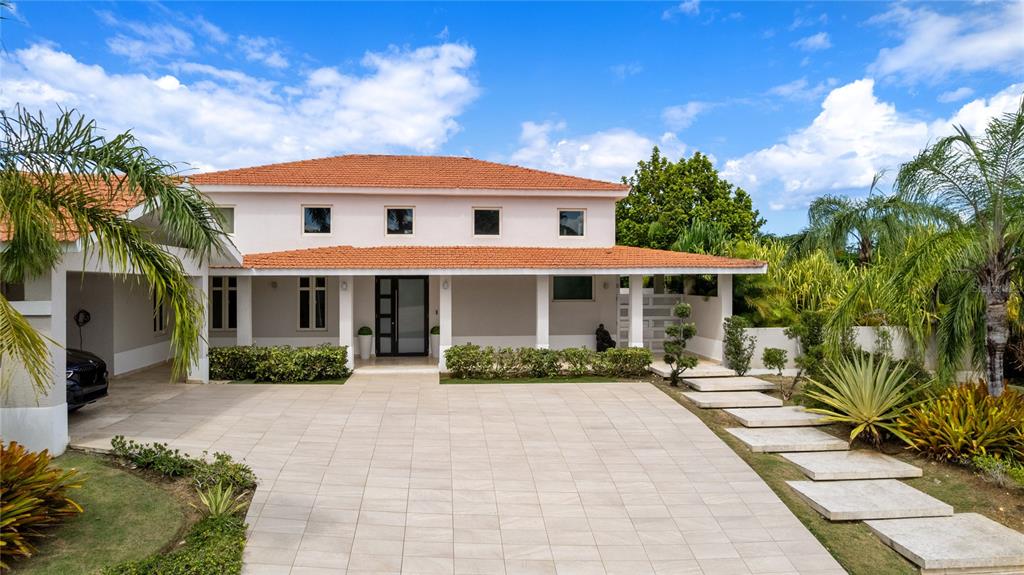 A two-story house with a tiled roof, covered entryway, and a large paved driveway — Sabanera Dorado CAMINO DEL FLAMBOYAN STREET UNIT 247, DORADO, PR