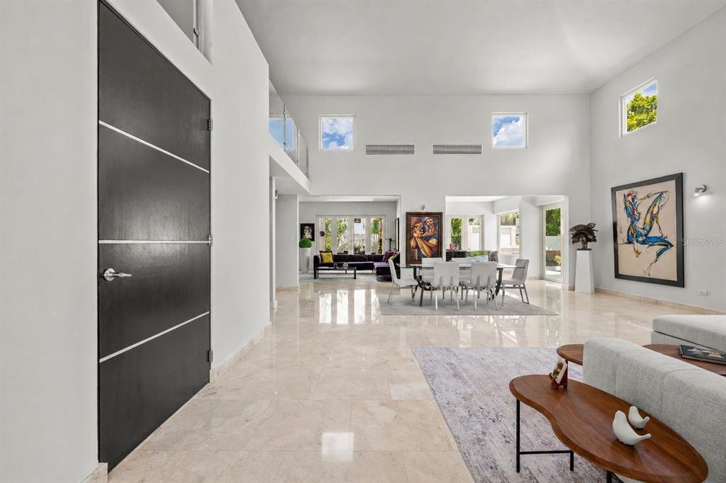 A spacious, high-ceilinged foyer and living area with white walls, tile floors, and modern decor — Sabanera Dorado CAMINO DEL FLAMBOYAN STREET UNIT 247, DORADO, PR